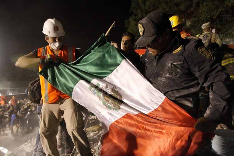 Rescue workers unfurling Mexican flag.